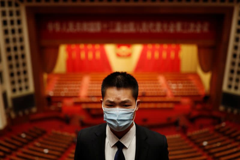 Security member keeps watch at the end of the opening session of NPC in Beijing