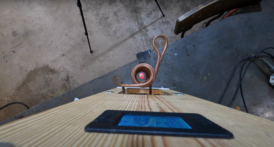 A piece of molten steel levitating inside of a ring of electrified metal coil.