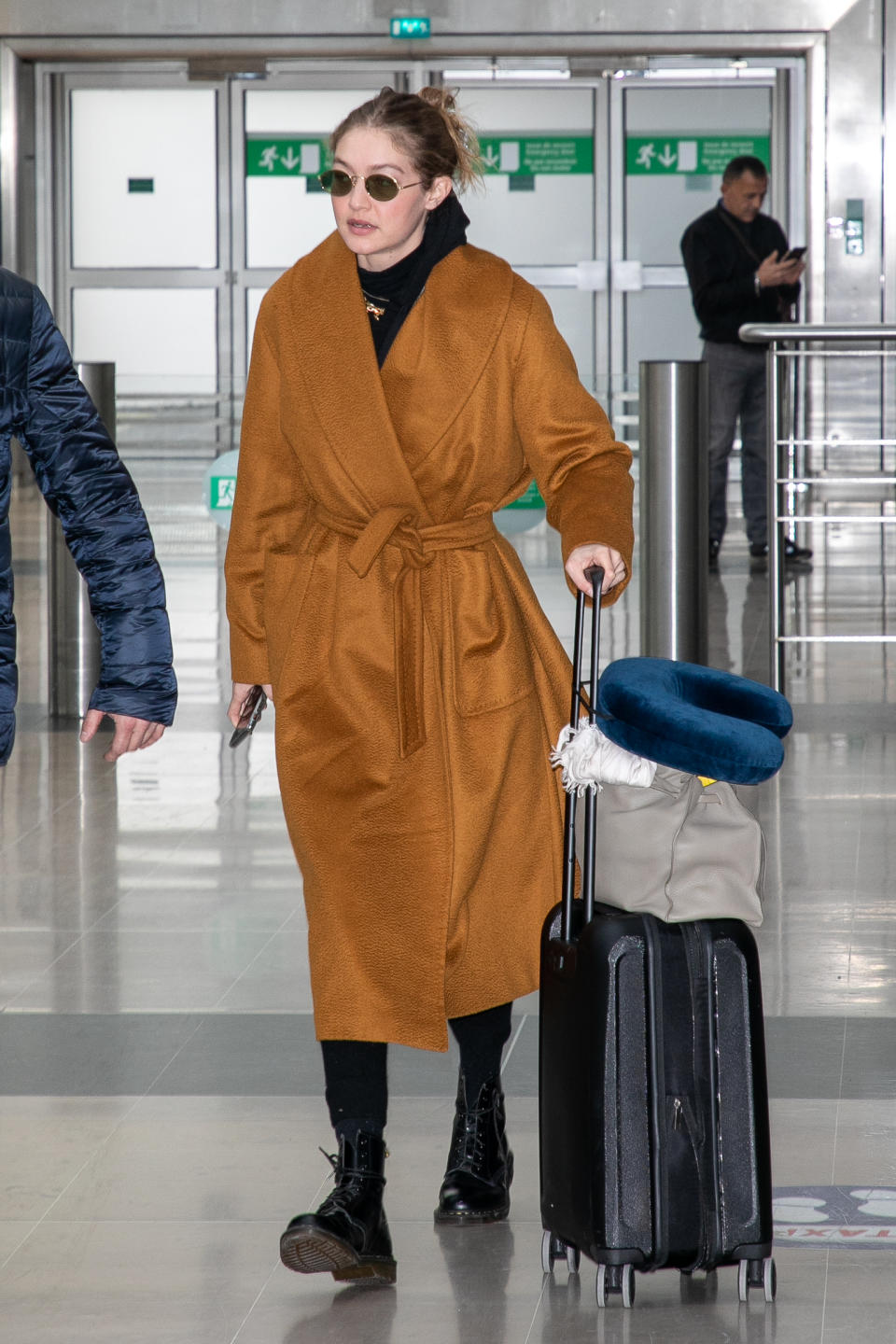 Gigi Hadid wears a wrap coat at Charles de Gaulle airport. (Credit: Getty Images)