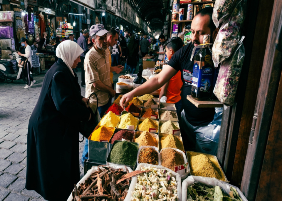People buying spices at a street market in Damascus