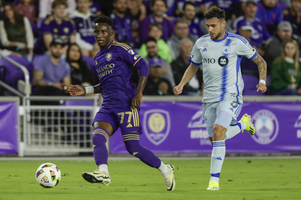 Orlando City forward Iván Angulo (77) and CF Montréal midfielder Dominic Iankov chase the ball during the first half of an MLS soccer match Saturday, Feb. 24, 2024, in Orlando, Fla. (AP Photo/Kevin Kolczynski)