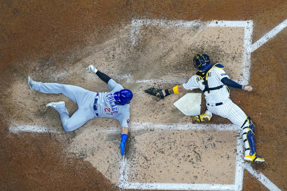 Chicago Cubs' Seiya Suzuki scores past Milwaukee Brewers catcher Victor Caratini during the fourth inning of a baseball game Saturday, Sept. 30, 2023, in Milwaukee. (AP Photo/Morry Gash)