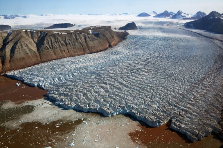 This aerial view taken on July 20, 2015 shows the Kronebreen glacier with red traces of sediments near the scientific base of Ny-Alesund