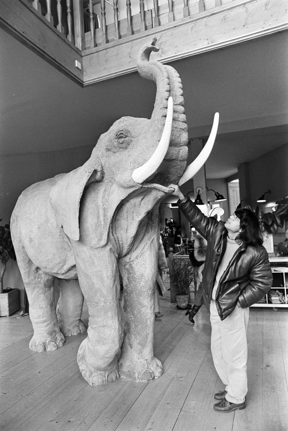 Designer Kenzo Takada poses with a sculpture of an elephant in Paris, France, on February 10, 1978. (Photo by Guy Marineau/WWD/Penske Media via Getty Images)