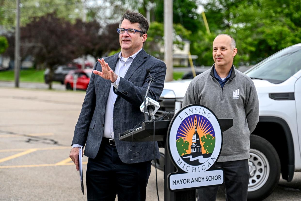 CATA CEO Brad Funkhouser, left, speaks during a press conference at the proposed site of city hall at a parking lot on Grand Avenue across from CATA's downtown transportation center on Thursday, May 9, 2024, in Lansing. At right, Mayor Andy Schor looks on.