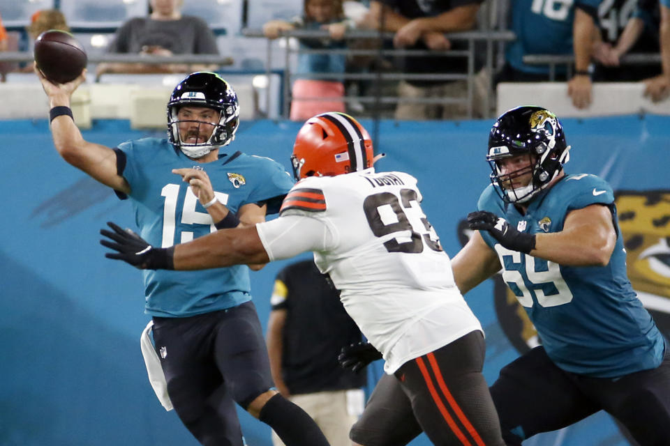 Jacksonville Jaguars quarterback Gardner Minshew (15) throws a pass as he is pressured by Cleveland Browns defensive tackle Tommy Togiai (93) during the first half of an NFL preseason football game, Saturday, Aug. 14, 2021, in Jacksonville, Fla. (AP Photo/Stephen B. Morton)