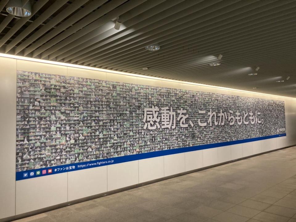 日本火腿在札幌車站以數千張札幌巨蛋歷年名場面照片拚成巨幅看板。取自日本火腿推特