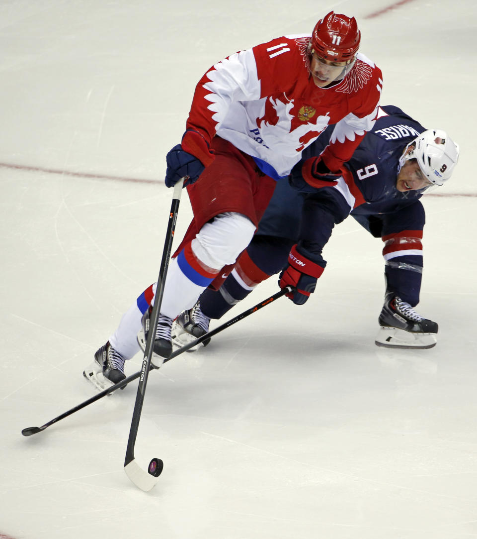 Russia forward Yevgeni Malkin and USA forward Zach Parise battle for the puck in the third period of a men's ice hockey game at the 2014 Winter Olympics, Saturday, Feb. 15, 2014, in Sochi, Russia. (AP Photo/Petr David Josek)