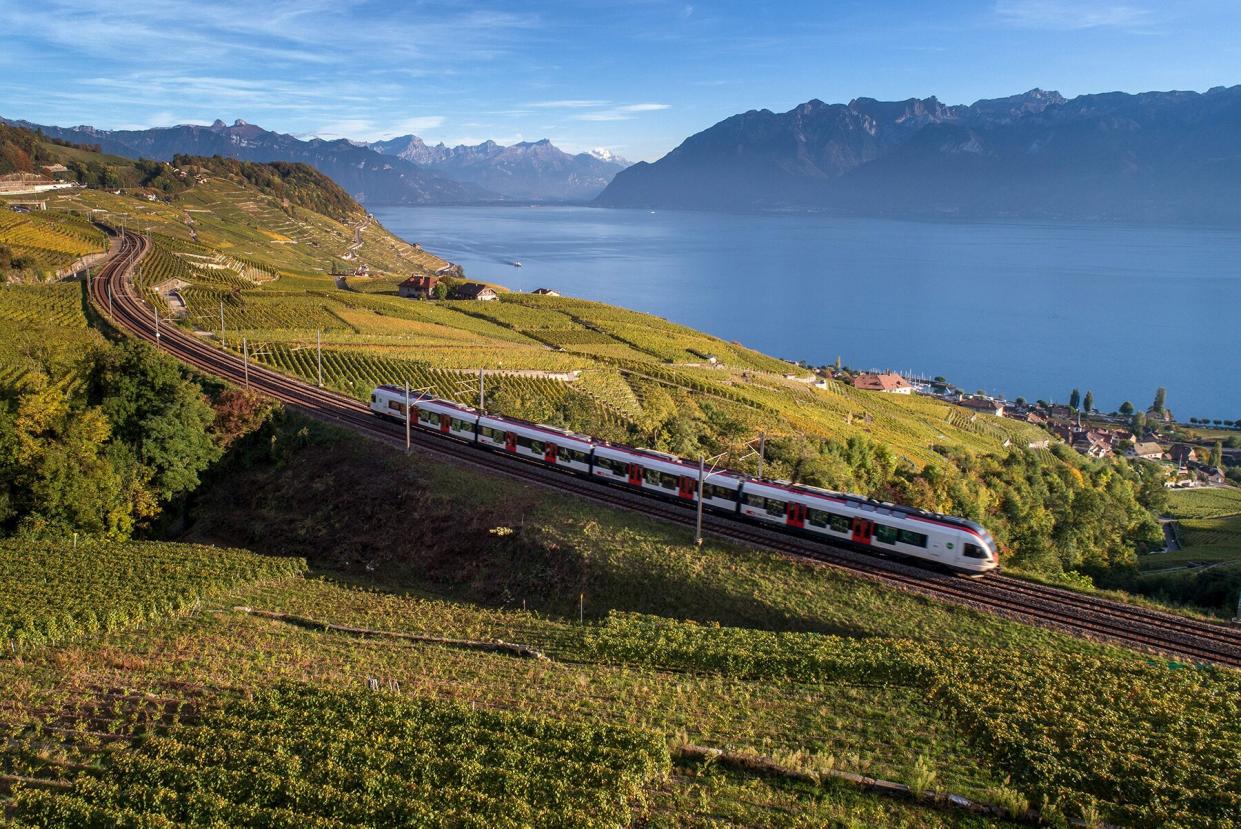 SBB Train in Switzerland travels through farm and lakeland.