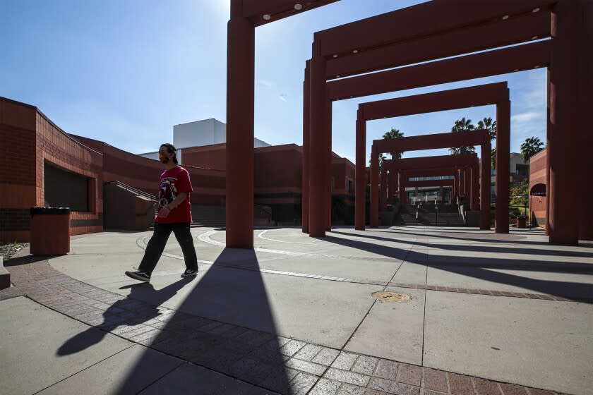 Los Angeles, CA - February 03: One of the two new COVID-19 vaccine center in California will be established at Cal State University. Savian Joseph, 20, after giving COVID-19 test walks under the arches of Harriet and Charles Luckman Fine Arts Complex at Cal State University on Wednesday, Feb. 3, 2021 in Los Angeles, CA.(Irfan Khan / Los Angeles Times)