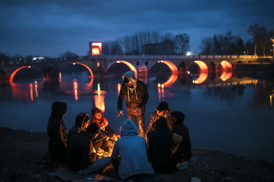 Migrants sit around a fire in Edirne near the Turkish-Greek border on Thursday, March 5, 2020. Turkey said Thursday it would deploy special forces along its land border with Greece to prevent Greek authorities from pushing back migrants trying to cross into Europe, after Turkey declared its previously guarded gateways to Europe open. (AP Photo/Emrah Gurel)