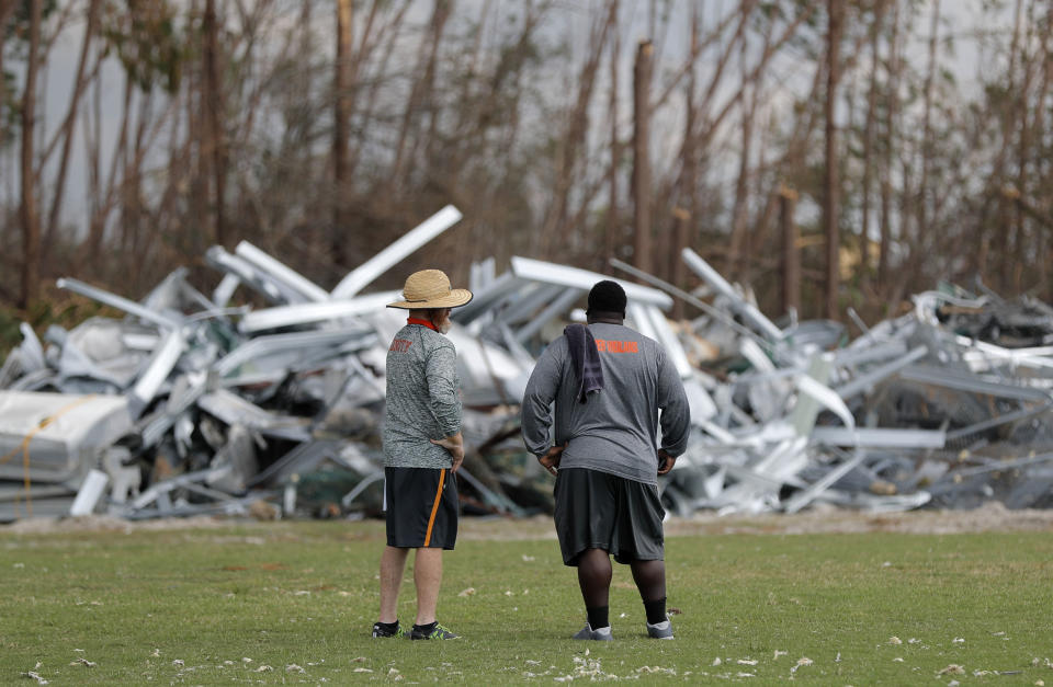 Mosley High defensive coordinator Danny Nagy, left, and defensive line coach William Mosley, survey damage to their football practice field, in the aftermath of Hurricane Michael in Lynn Haven, Fla., Friday, Oct. 19, 2018. (AP Photo/Gerald Herbert)