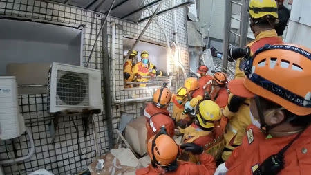 Rescuers evacuate a building due to an aftershock in Hualien, Taiwan February 8, 2018 in this still image obtained from social media video. Eastern Division Search and Rescue Team via REUTERS