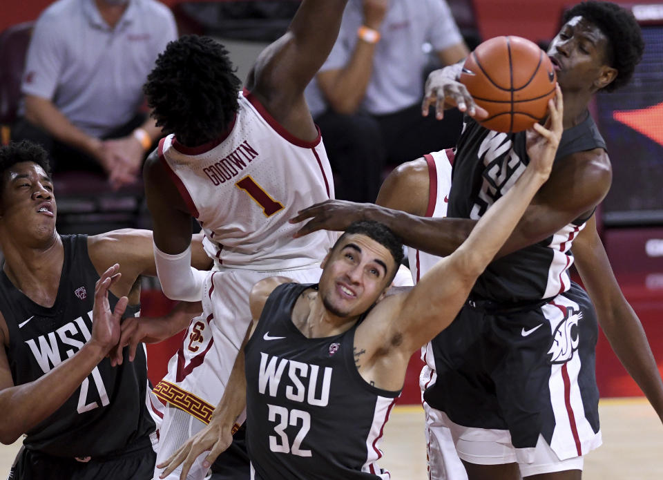 Washington State's Tony Miller pulls in a rebound next to Southern California's Chevez Goodwin during the first half of an NCAA college basketball game in Los Angeles on Saturday, Jan. 16, 2021. (Keith Birmingham/The Orange County Register via AP)