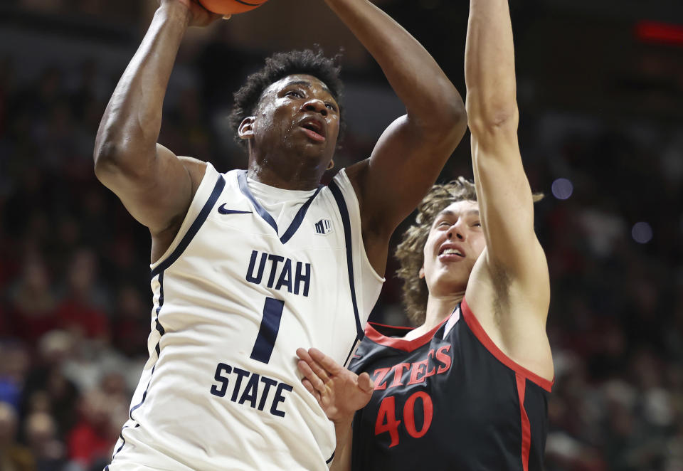 Utah State forward Great Osobor (1) goes up for a shot next to San Diego State forward Miles Heide (40) during the first half of an NCAA college basketball game in the semifinals of the Mountain West Conference men's tournament Friday, March 15, 2024, in Las Vegas. San Diego State won 86-70. (AP Photo/Ronda Churchill)