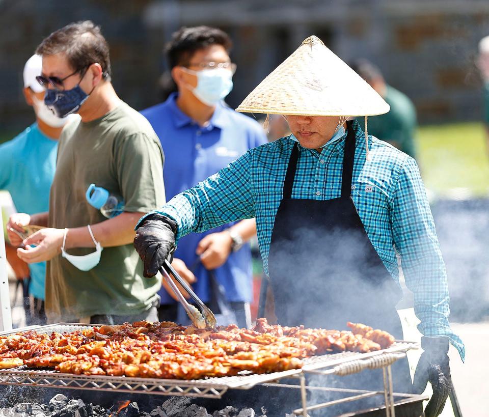 Anan Ruang cooks chicken at the August Moon Festival in Quincy on Sunday, Aug. 15, 2021.