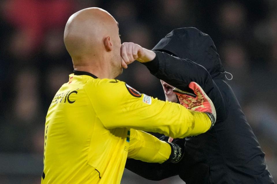 A PSV supporter punches Sevilla’s goalkeeper Marko Dmitrovic in the face (Peter Dejong/AP) (AP)