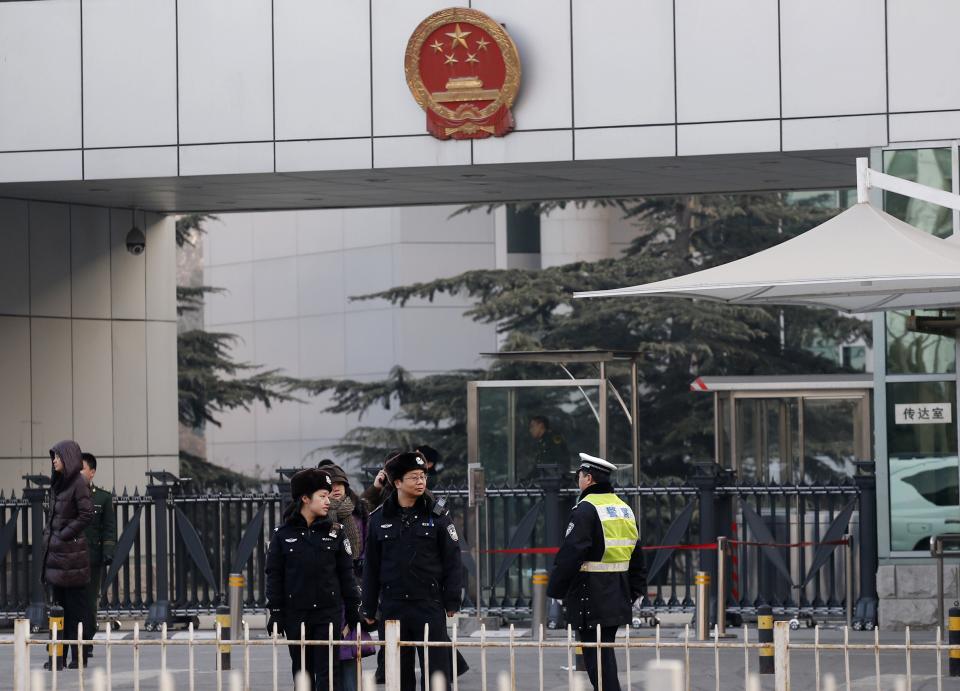 Policemen stand guard in front of the court building where the trial of Xu Zhiyong, one of China's most prominent rights advocates, is going to be held in Beijing