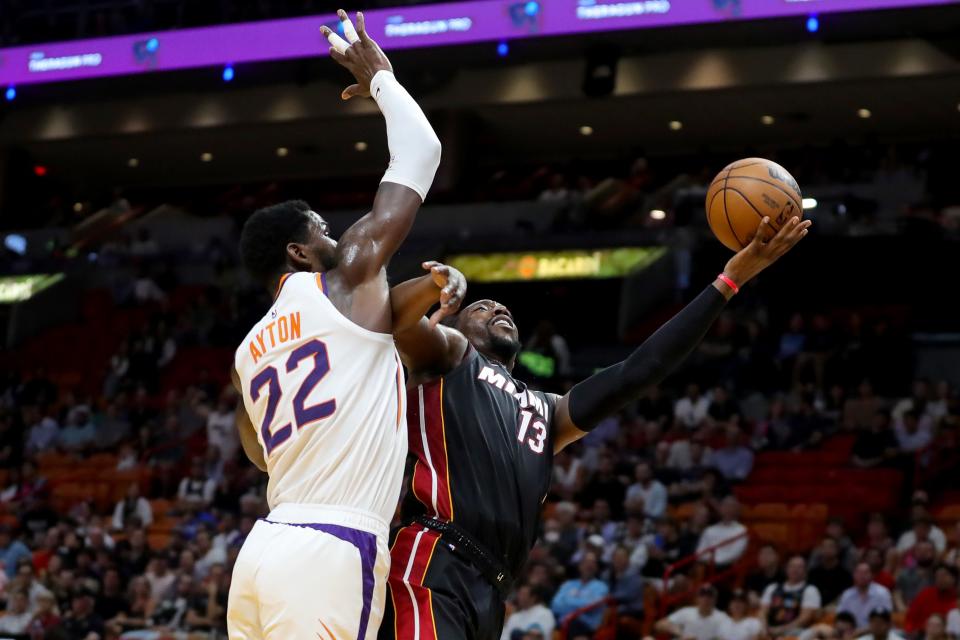 Bam Adebayo #13 of the Miami Heat shoots past Deandre Ayton #22 of the Phoenix Suns during the first quarter at FTX Arena on November 14, 2022, in Miami, Florida.