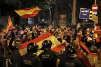 Right wing pro-Spanish unity supporters challenge police officers during a demonstration in Barcelona, Spain, Thursday, Oct. 17, 2019. Catalonia's separatist leader vowed Thursday to hold a new vote to secede from Spain in less than two years as the embattled northeastern region grapples with a wave of violence that has tarnished a movement proud of its peaceful activism. (AP Photo/Emilio Morenatti)