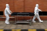 Nurses take the body of Isidra Coronel to the morgue after removing her body from a hospital bed where she died from the new coronavirus at Hospital de Clinicas in San Lorenzo, Paraguay, Friday, June 18, 2021. A coronavirus wave has resulted in a flood of patients infected with the virus overwhelming intensive care units and a surge in the country’s COVID-19 death toll. (AP Photo/Jorge Saenz)