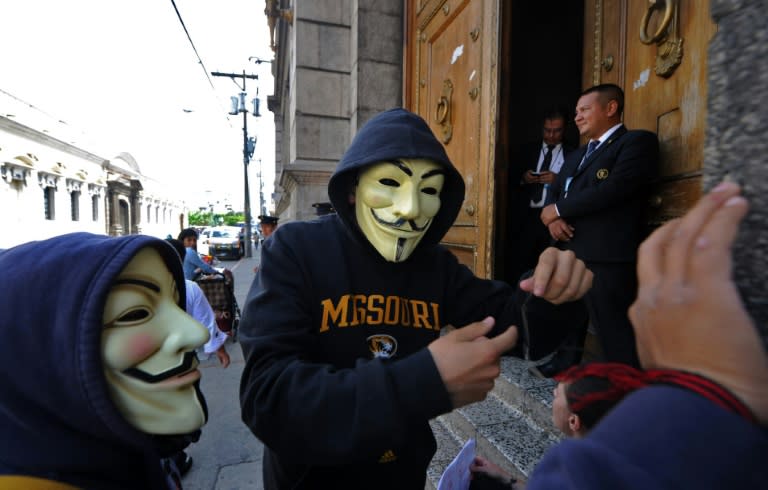 Students in Guy Fawkes masks demand the resignation of Guatemalan President Otto Perez over a corruption scandal, outside the Congress building in Guatemala City on August 28, 2015