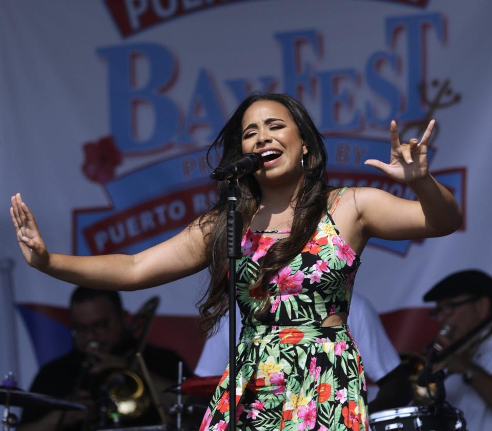 Shawnee "EhShawnee" Taveras gets the crowd moving while singing with her band at the July 28 Puerto Rican Bay Fest at Providence's India Point Park. [The Providence Journal / Kris Craig]