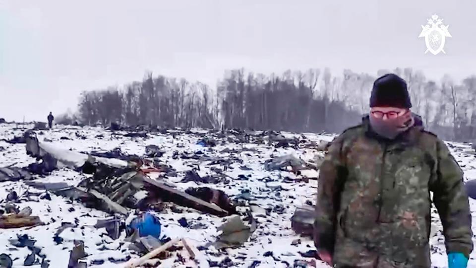 A Russian Investigative Committee employee walks near the wreckage of the Russian military Il-76 plane that crashed near Yablonovo, in the Belgorod region of Russia (Russian Investigative Committee)