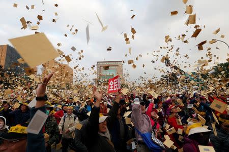 Protesters throw hell money during a rally against the overhaul of the military and civil service pension fund, outside the Presidential Office in Taipei,Taiwan January 22, 2017. REUTERS/Tyrone Siu