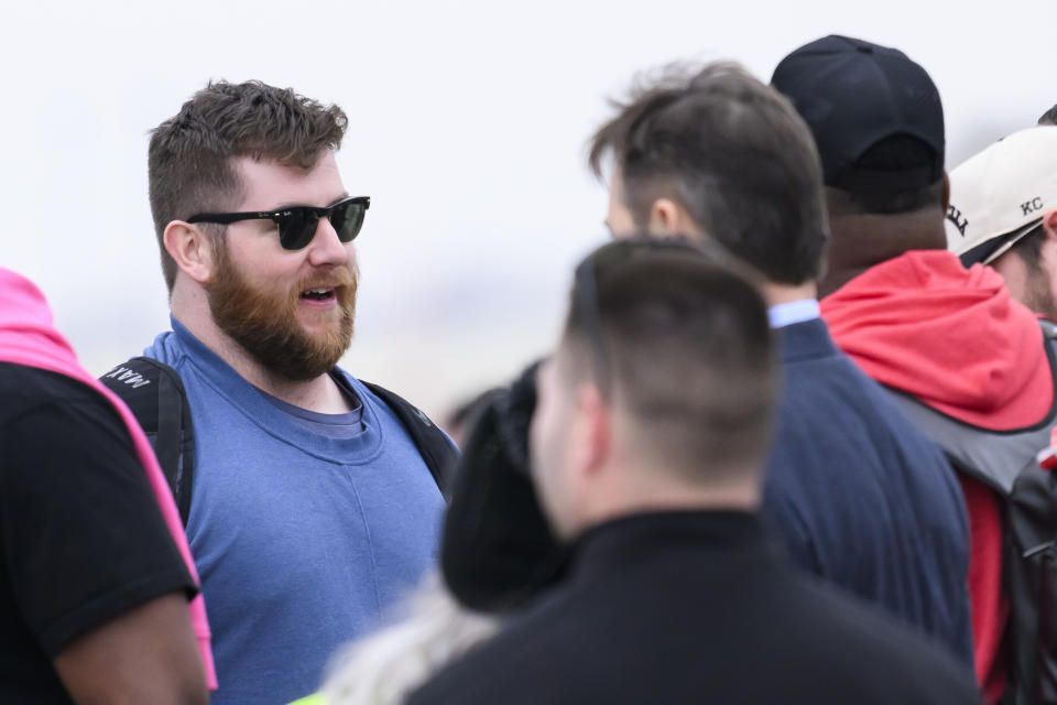 Kansas City Chiefs guard Joe Thuney, left, talks to teammates as they wait to board a plane at Kansas City International Airport, Sunday, Feb. 4, 2024, in Kansas City, Mo., bound for Las Vegas and Super Bowl 58. (AP Photo/Reed Hoffmann)