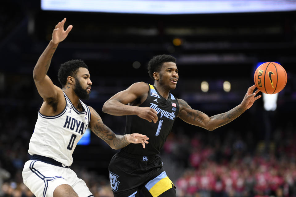 Marquette guard Kam Jones (1) passes off as Georgetown guard Dontrez Styles (0) defends during the first half of an NCAA college basketball game, Saturday, Feb. 3, 2024, in Washington. (AP Photo/Nick Wass)