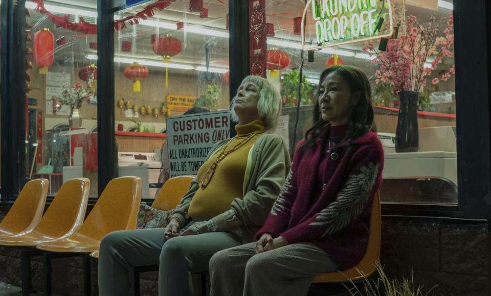 Two women sit in silence at a laundromat in a scene from "Everything Everywhere All at Once."