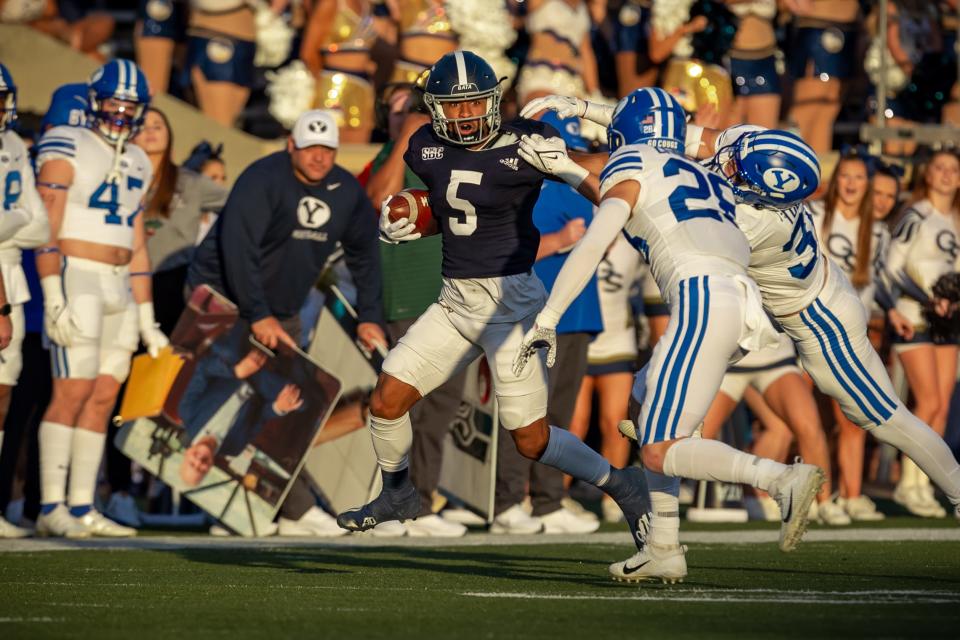 Georgia Southern senior Amare Jones (5) takes on two would-be tacklers from BYU on Nov. 20, 2021 at Paulson Stadium in Statesboro. No. 14 BYU won 34-17.