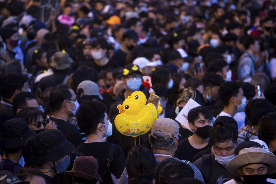 Inflatable yellow ducks, which have become a good-humored symbol of resistance during anti-government rallies, are held by a protester during a rally Wednesday, Nov. 25, 2020 in Bangkok, Thailand. Pro-democracy demonstrators in Thailand on Wednesday again took to the streets of the capital, even as the government escalated its legal battle against them, reviving the use of a harsh law against defaming the monarchy. (AP Photo/Wason Wanichakorn)