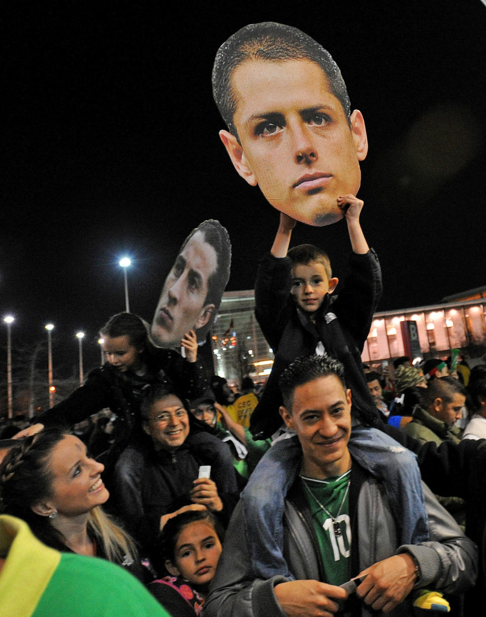 Soccer fans hold photos of soccer players before an international friendly soccer match between Mexico and Nigeria on Wednesday, March 5, 2014, in Atlanta. (AP Photo/David Tulis)