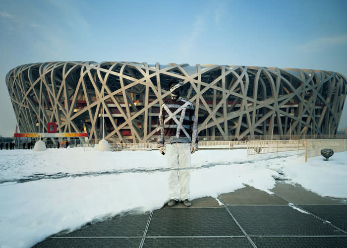 Liu Bolin poses by the Bird's Nest Olympic stadium in Beijing.