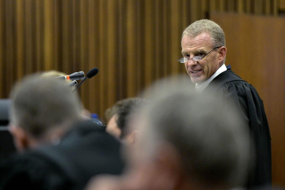 State prosecutor Gerrie Nel reads out the charge sheet during the trial of Olympic and Paralympic track star Oscar Pistorius at the North Gauteng High Court in Pretoria March 3, 2014. "Blade Runner" Pistorius pleaded not guilty on Monday to murdering his girlfriend at the start of a trial with massive media cover that could see one of global sports' most admired role models go to jail for life. REUTERS/Herman Verwey/Pool (SOUTH AFRICA - Tags: SPORT ATHLETICS CRIME LAW)