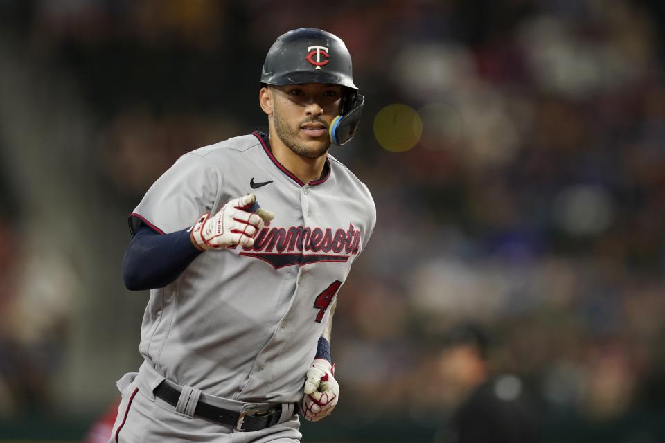 Minnesota Twins' Carlos Correa points as he rounds third after hitting a two-run home run in the first inning of the team's baseball game against the Texas Rangers, Friday, July 8, 2022, in Arlington, Texas. (AP Photo/Tony Gutierrez)