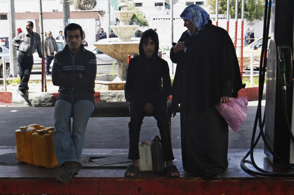 Palestinians wait to fill up canisters with fuel at a gas station in Gaza City, Wednesday, March 21, 2012. A test of wills between Egypt and Gaza's Hamas government has produced the worst energy crisis here in years: Gazans are enduring 18-hour-a-day blackouts and the fuel supply is running low. (AP Photo/Adel Hana)