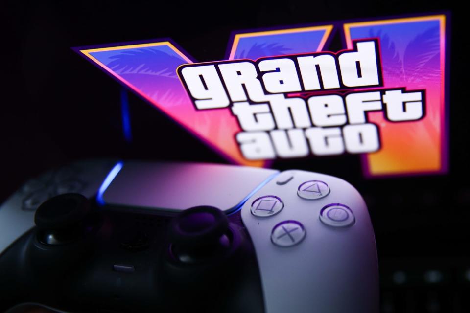 Das GTA VI-Logo aus dem Trailer wird auf einem Laptop-Bildschirm hinter einem PlayStation DualSense-Controller angezeigt. - Copyright: Getty Images