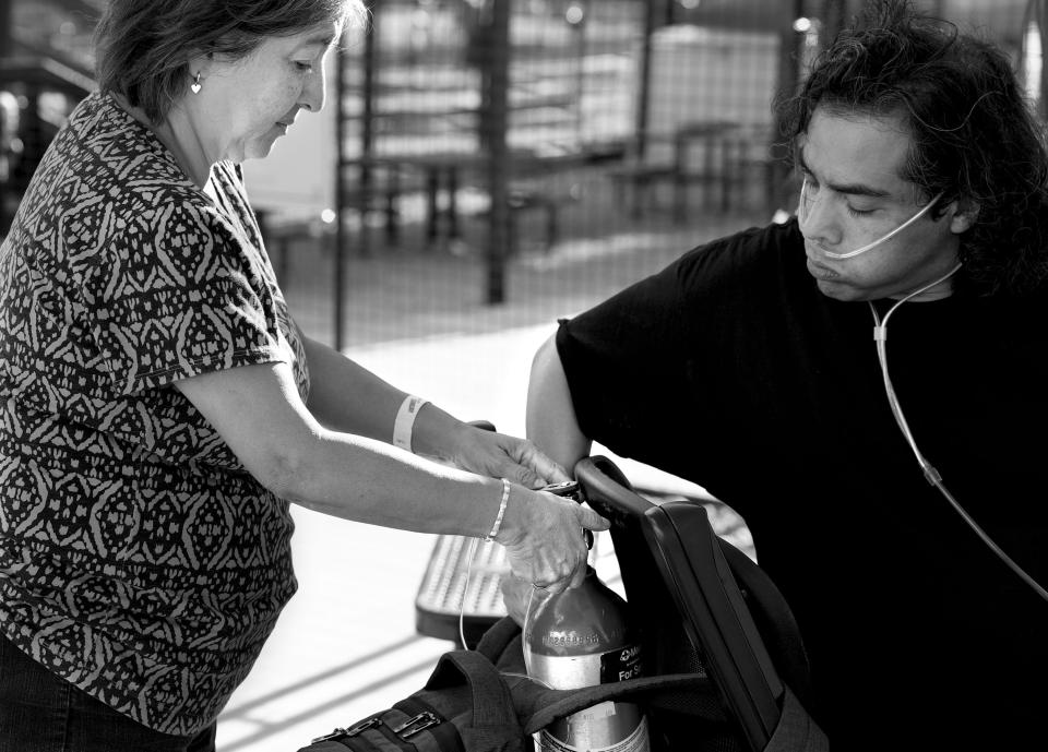 Rita Orosco helps her son Issaac Chavez change his oxygen tank during a family outing at Park City Mountain Resort on Sunday, Aug. 6, 2023. It was the last family outing for the famly; he died three weeks later of lung cancer. | Laura Seitz, Deseret News