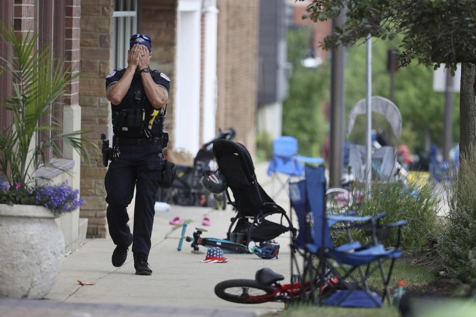 PHOTO: A Lake County, Illinois, police officer walks down Central Avenue in Highland Park, July 4, 2022, after a shooter opened fire at the Fourth of July parade. (Chicago Tribune/Tribune News Service via Getty Images)