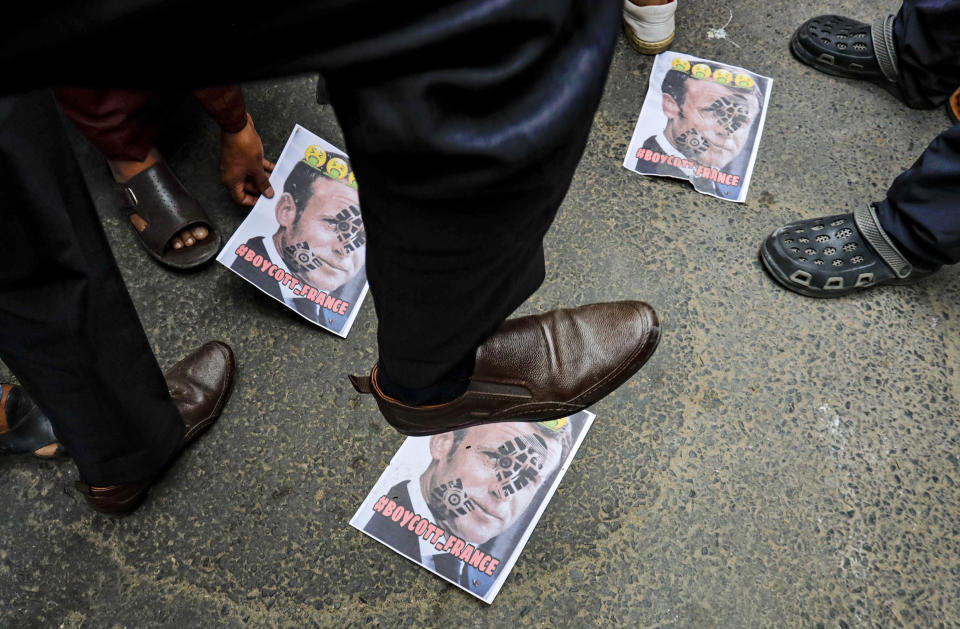 A Muslim activist stamps on posters bearing defaced images of French President Emmanuel Macron during a protest near the French Consulate, in Kolkata, India, Saturday, Oct. 31, 2020. Muslims have been calling for both protests and a boycott of French goods in response to France's stance on caricatures of Islam's most revered prophet. (AP Photo/Bikas Das)