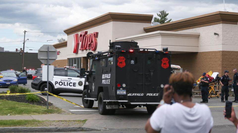 A crowd gathers as police investigate after a shooting at a supermarket on Saturday, May 14, 2022, in Buffalo, N.Y. Multiple people were shot  at the Tops Friendly Market.  Police have notified the public that the alleged shooter was in custody. (AP Photo/Joshua Bessex)