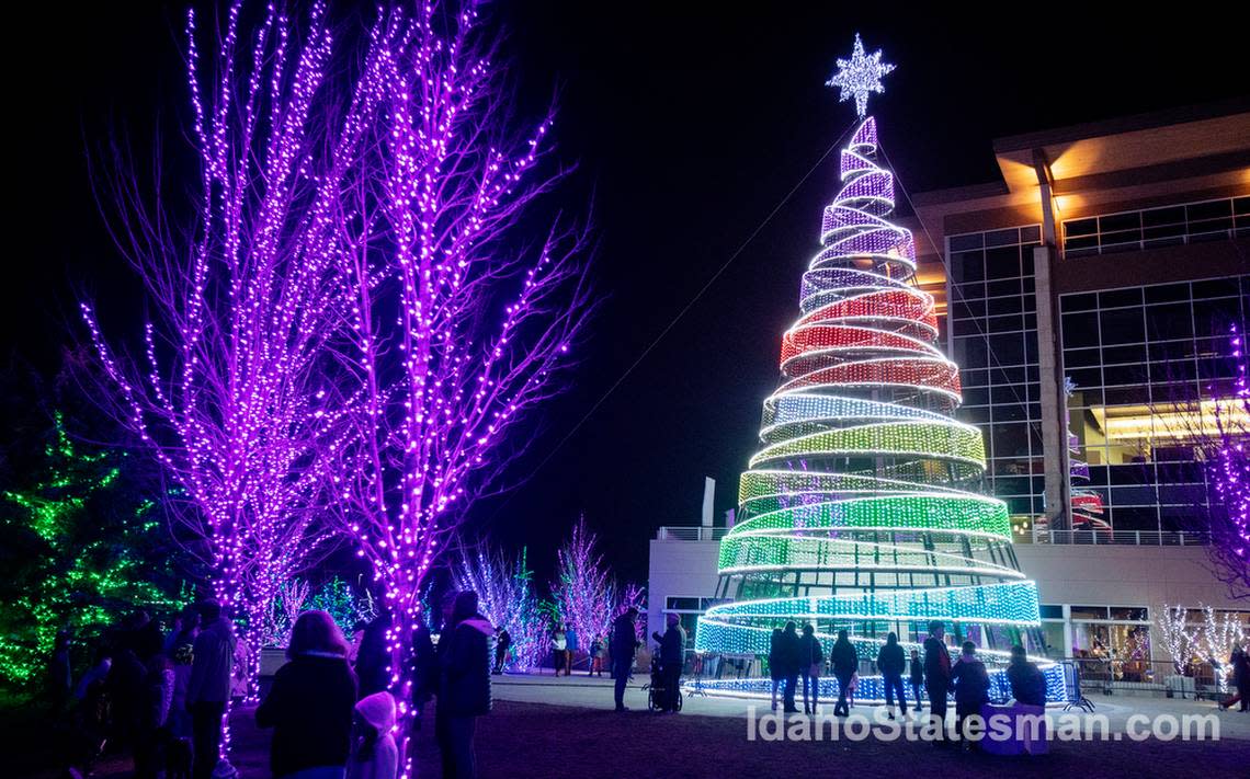 People walk by a 75-foot tall Christmas light tree at Scentsy Commons in Meridian in 2021.