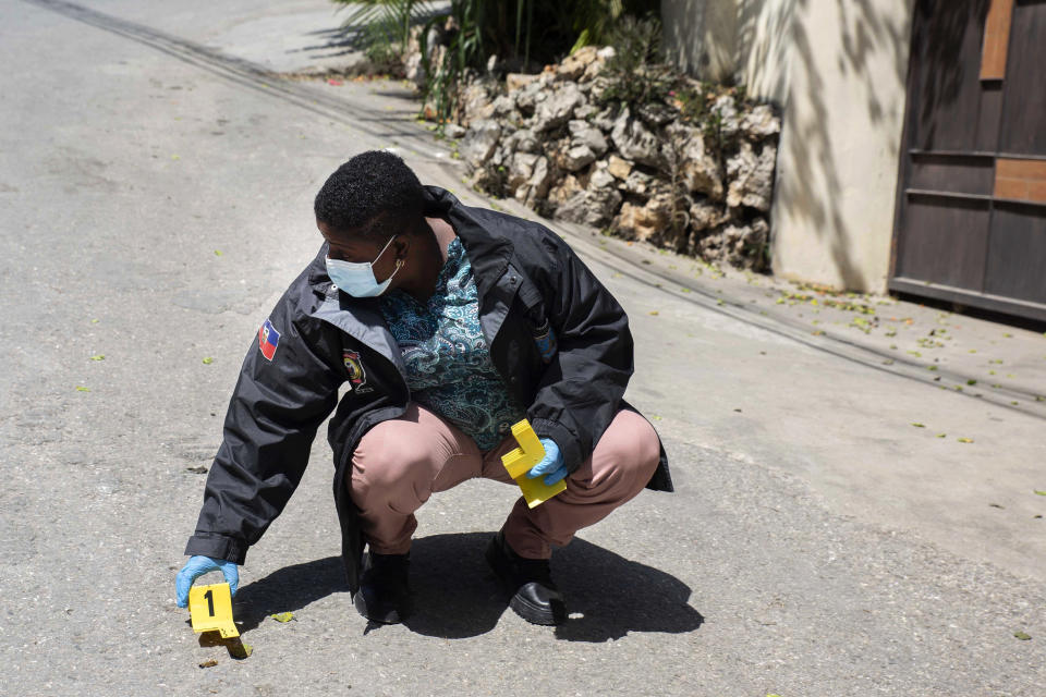 An investigator places an evidence marker next to a bullet casing outside the residence of Haitian President Jovenel Moise, in Port-au-Prince, Haiti, Wednesday, July 7, 2021. Gunmen assassinated Moise and wounded his wife in their home early Wednesday. (AP Photo/Joseph Odelyn)
