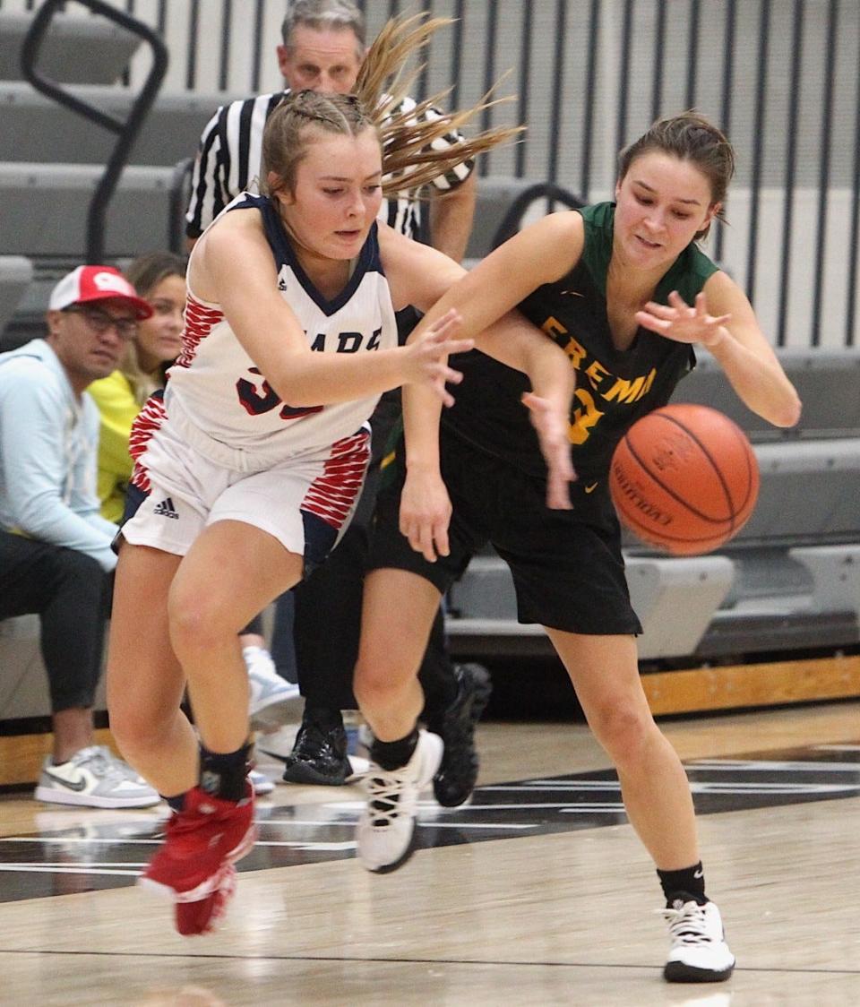 BNL's Madison Bailey (left) battles Fremd's Anna Schmitt for a loose ball Saturday night at the Sneakers for Santa Shootout in Brownsburg.