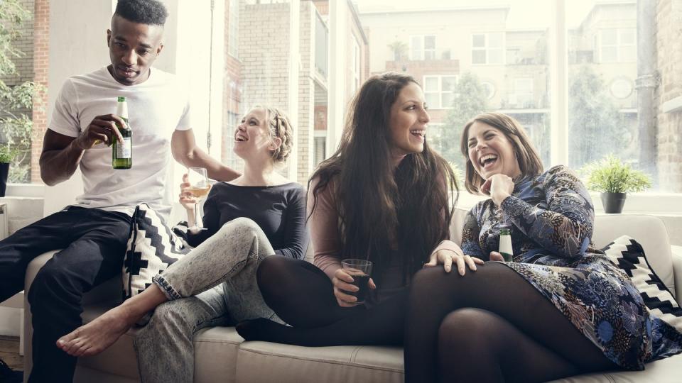 group of young people having a party, telling jokes, having a good time, celebrating, in a private home