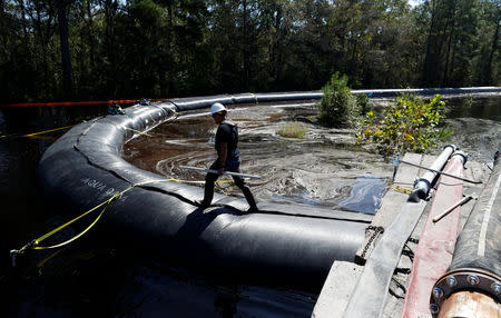 A Santee Cooper worker checks the water levels around a 6000 foot long Aqua Dam built to keep sediment from a coal ash retention pond from going into the flooded Waccamaw River in the aftermath of Hurricane Florence in Conway, South Carolina, U.S. September 26, 2018. REUTERS/Randall Hill