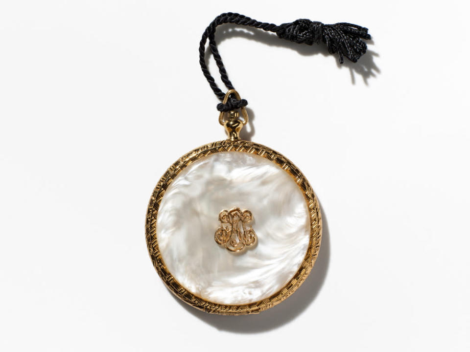 <p>This compact has a mother of pearl face and a black tassel and was part of the first Christmas Golden Damask holiday collection. The design was remade in 1999, but the original is smaller in size and more delicate overall. (Photo: Henry Leutwyler)</p>